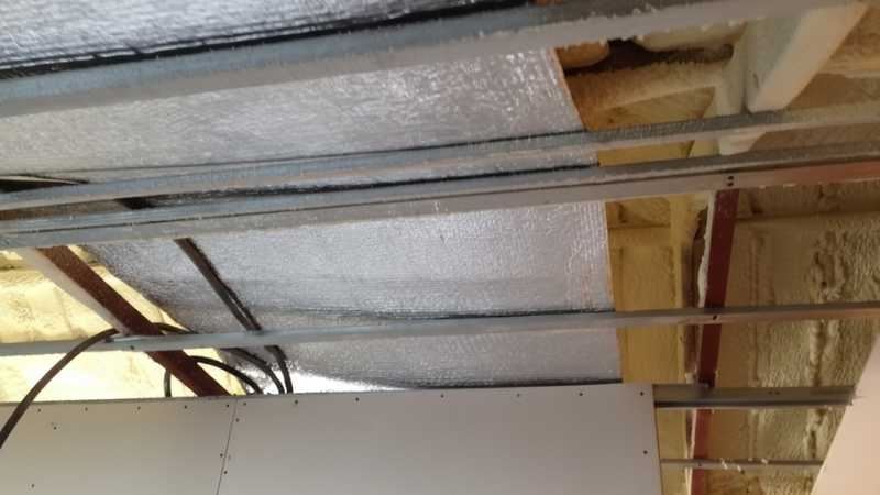 Click to open large image תקרת עליית גג בתהליך התקנה עם יריעת בידוד רפלקטיבית וקונסטרוקציית מתכת חשופה